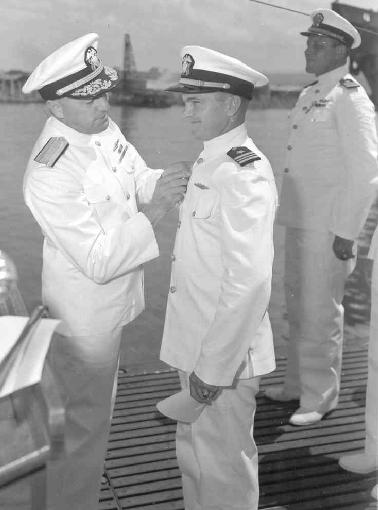 Adm Lockwood pinning the Silver Star on Cdr Bass