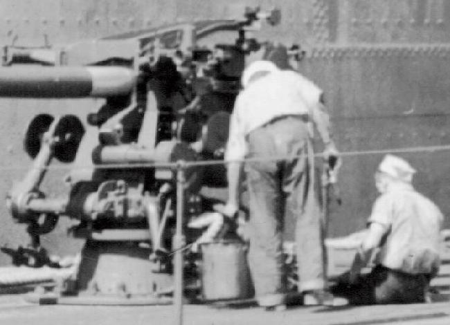 Close-up of crew members doing gun maintinance