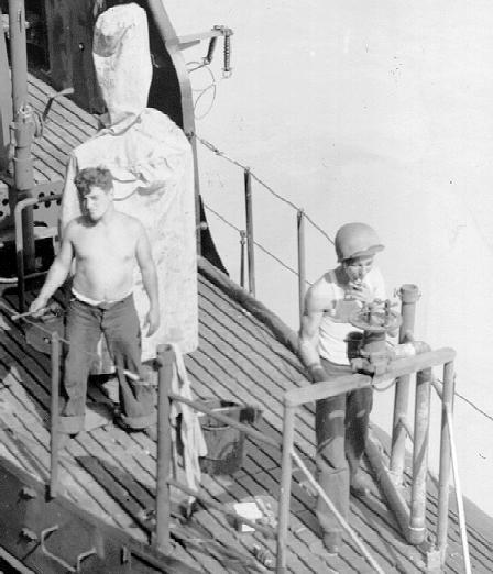 Detail of men on after gun deck of conning tower