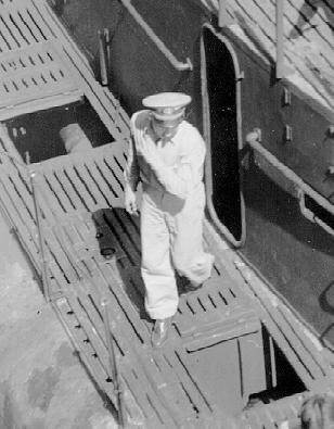 Offier stepping out of conning tower deck access and avoiding open hatch