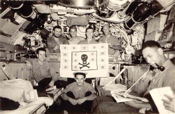 Crew in forward torpedo room with battle flag